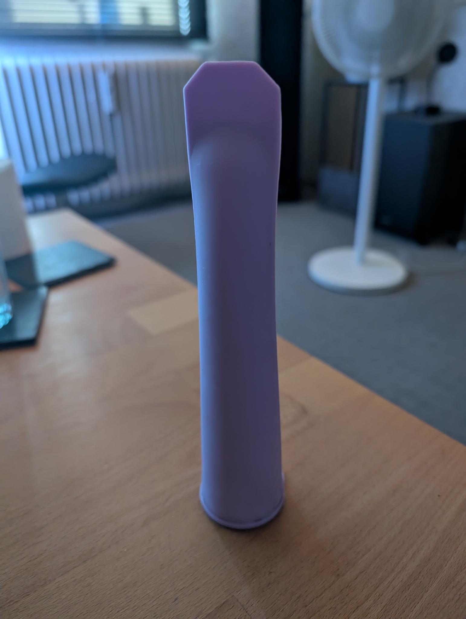 Die Eistüte ungeöffnet und auf dem Kopf auf einem Holztisch stehend. Die Eistüte ungeöffnet und auf dem Kopf auf einem Holztisch stehend.